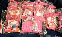 Closer view of six Hello Kitty McDonald's Happy Meal Toys in sealed pink bags with numbers 4 to 8 visible, showing character design, outfits, and packaging condition.