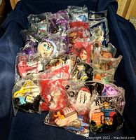 Overview photo showing multiple vintage McDonald's Happy Meal toys sealed in original plastic packaging.