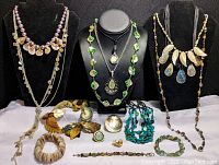 Full view of mother of pearl and abalone jewelry lot on display stands, showing necklaces, bracelets, earrings, and rings made from shells and beads.