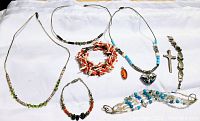 Full lot of vintage Native American sterling silver jewelry with amber, coral, turquoise, fetish pieces laid out showing variety of necklaces, bracelets, and pendants.