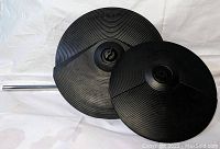 Two Roland electronic cymbal pads, one larger and one smaller, shown laid flat on a white surface