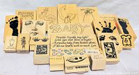 Photo of 22 baby themed rubber stamps on wooden blocks showing various designs including footprints, handprints, faces, animals, and text.