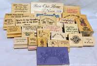 Photo of 26 wooden rubber stamps with various inspirational phrases and a large purple rubber stamp showing people holding hands.