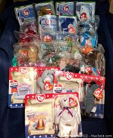 Photo showing multiple mini TY Beanie Babies in sealed plastic bags and original boxed packaging with patriotic USA themed backgrounds.
