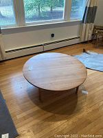 Table viewed from front showing round top and legs