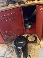 Krups Beertender beer tap system near kitchen cabinet with wire spice rack and round metal trays visible