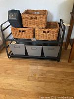Front view of metal shelving with wicker baskets on top and gray metal boxes below