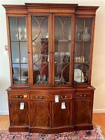 Front view of the two-piece mahogany china cabinet with glass doors and wood lattice design.