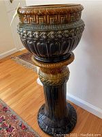Full view of the assembled Majolica planter and pedestal showing overall shape, colors, and decorative patterns.