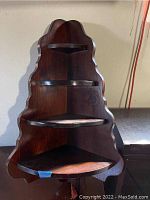 Front view of the solid wood corner shelf with three shelves and scalloped edges.