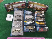 Lot of 11 Maisto toy vehicles including two transport hauler trucks, a five-piece set of silver cars, and assorted boxed vehicles