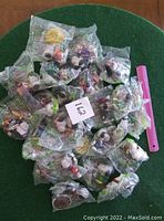 Multiple unopened Snoopy toys in original plastic packaging shown with ruler for scale; total of 22 toys