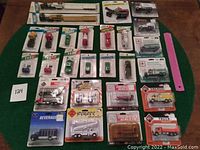 Full spread of all 27 toys in original packaging arranged on green surface.