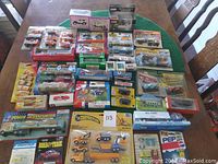 Full overview of 37 toy cars and trucks in boxes and blister packs arranged on table