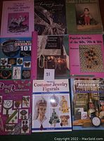 Photo of ten costume jewelry related books and magazines with titles visible including fashion jewelry, antique jewelry, costume jewelry, popular jewelry guides, and historical collectibles.