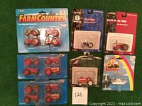 View of various ERTL die cast tractors in blister packs and one Carla Theodore Tugboat boat pack