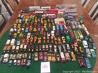 Top-down view of full assembly of approximately 95 die-cast vehicles on green felt