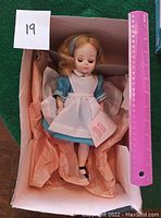 Full view of vintage Alice in Wonderland doll in box with ruler and lot number shown.