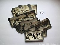 Thirty-two black and white curved 3D stereoview cards stacked and fanned showing partial images of diverse scenes.