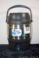 Front view of Bubba insulated jug showing stainless steel body, black plastic handle and base, and brand label.