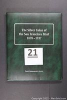 Front cover of green presentation album reading 'The Silver Coins of the San Francisco Mint 1878-1937'