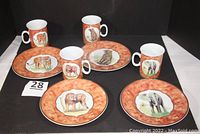 Overview of 4 dessert plates and 4 mugs with animal designs on marbled orange background
