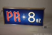 Front view of lighted Reading Brewing Co. bar sign illuminated in blue with red and white lettering "P R 8 oz."
