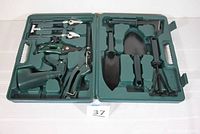 Full view of open green molded plastic carrying case displaying all 10 garden tools in place.