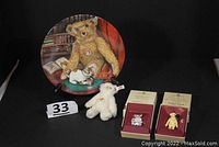 Photo showing all four lot items together: stuffed bear, porcelain plate with vintage bear scene, two boxed pewter items.