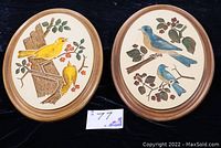 Both oval bird plaques side by side, showing yellow and blue birds with wood frames