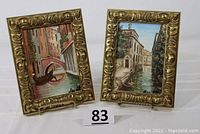 Two original oil paintings of Venice canals each in matching ornate gold-tone frames, displayed standing next to each other.