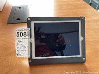 Apple iPad Mini resting in a black Kensington stand, front view, screen off.