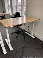 Desk with bamboo top and white T-legs, chair in background