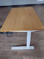 Full view of desk showing bamboo top and white steel T-leg base