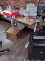 Front angled view of desk with bamboo top, white steel legs, and under-desk control box