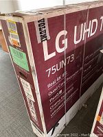 Front of sealed cardboard box showing LG UHD TV 75UN73 branding and packaging condition