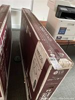 Two LG UHD TV boxes side by side, showing front and side packaging with AI ThinQ logo.