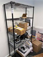 First image shows a fully assembled black metal wire rack loaded with various boxes and electronic items on shelves.