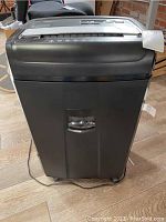 Front view of Amazon Basics office shredder showing overall size and wheels at the base.