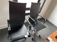 Two black Winport pneumatic office chairs side by side by a window, showing overall condition and style