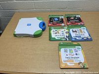 LeapStart system with main reader device and five accompanying themed activity books shown on a table.