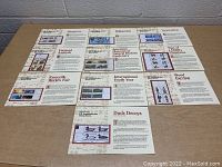 Top-down photo showing multiple 'Officially Numbered U.S. Commemorative Stamp Blocks' with corresponding thematic printed info sheets laid out on table.