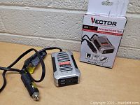 Power inverter connected to its box on table showing front and cable