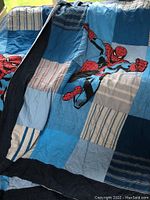 Front view of Spider-Man twin quilt with patchwork in different blue hues and striped patterns, showing the graphic of Spider-Man.