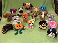Full lot view on green backdrop showing 16 assorted Ty Beanie Boos plush toys in various animal and character styles.