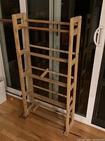 Front view of the natural wood media shelf showing multiple horizontal rails designed to hold CDs and DVDs.