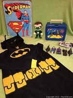 Display of entire DC Comics lot including Batman pajamas, Green Lantern figure, Superman metal sign, Batman lunch box, character-themed cars