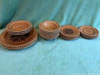 Stacked view of all dishes showing plates and bowls in a row with clear visibility of design and colors.