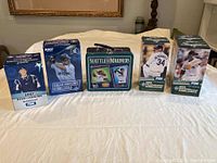 Full view showing 4 Mariners player bobblehead boxes and a Seattle Mariners lunch box on a surface.