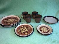 Photo of Noritake Safari stoneware plates in brown cream floral design and 4 brown textured Sango Omega Cocoa mugs